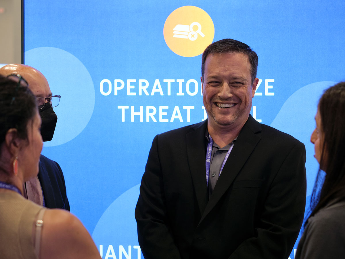 ThreatConnect team member laughing with a group of people at an event
