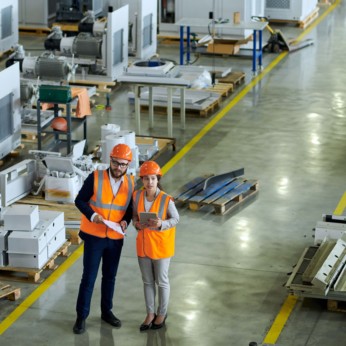 two manufacturing employees looking at things in a factory