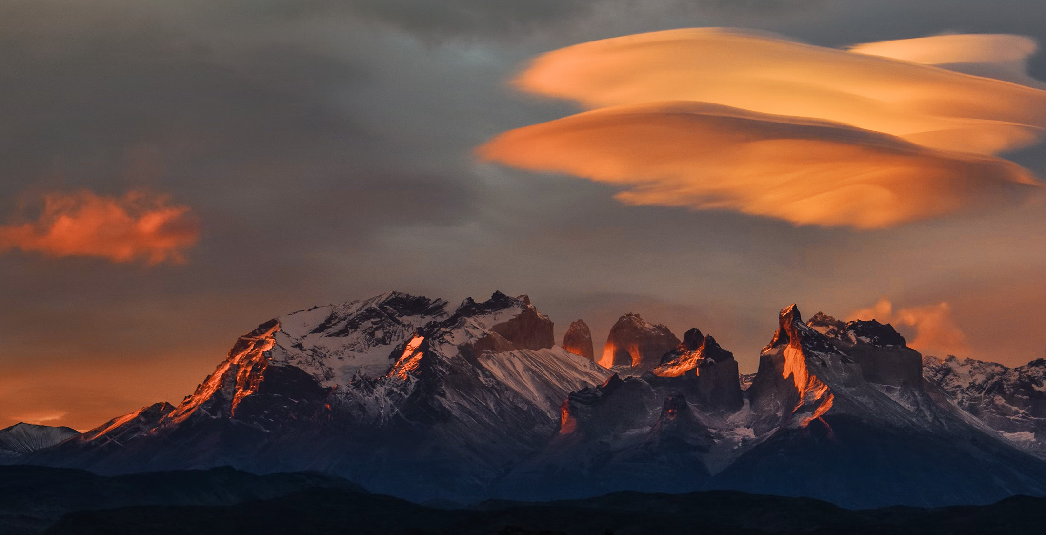 a snowy mountain with a cloudy sky in the background